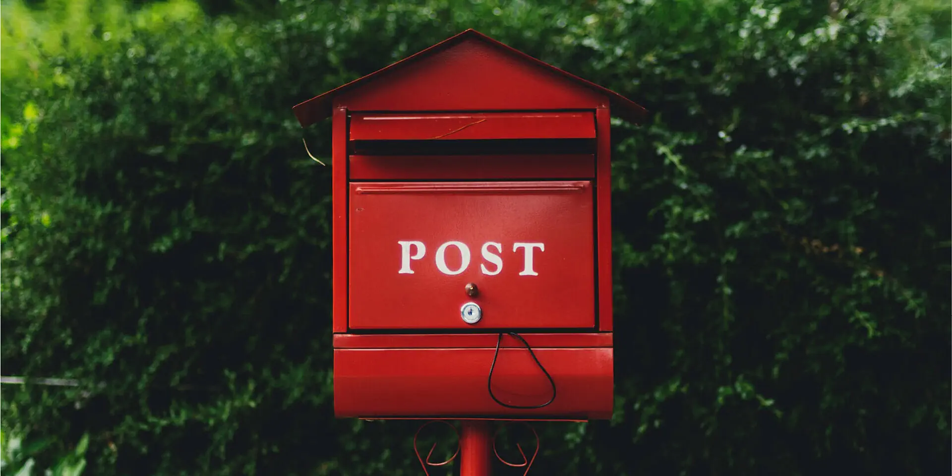 Katharina Schulte Kontakt. Ein alter roter amerikanischer Postkasten vor Pflanzen